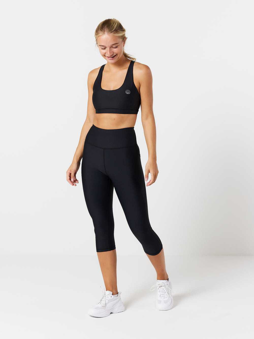 kvinde forfra med 3/4 tights i sort og sports bh