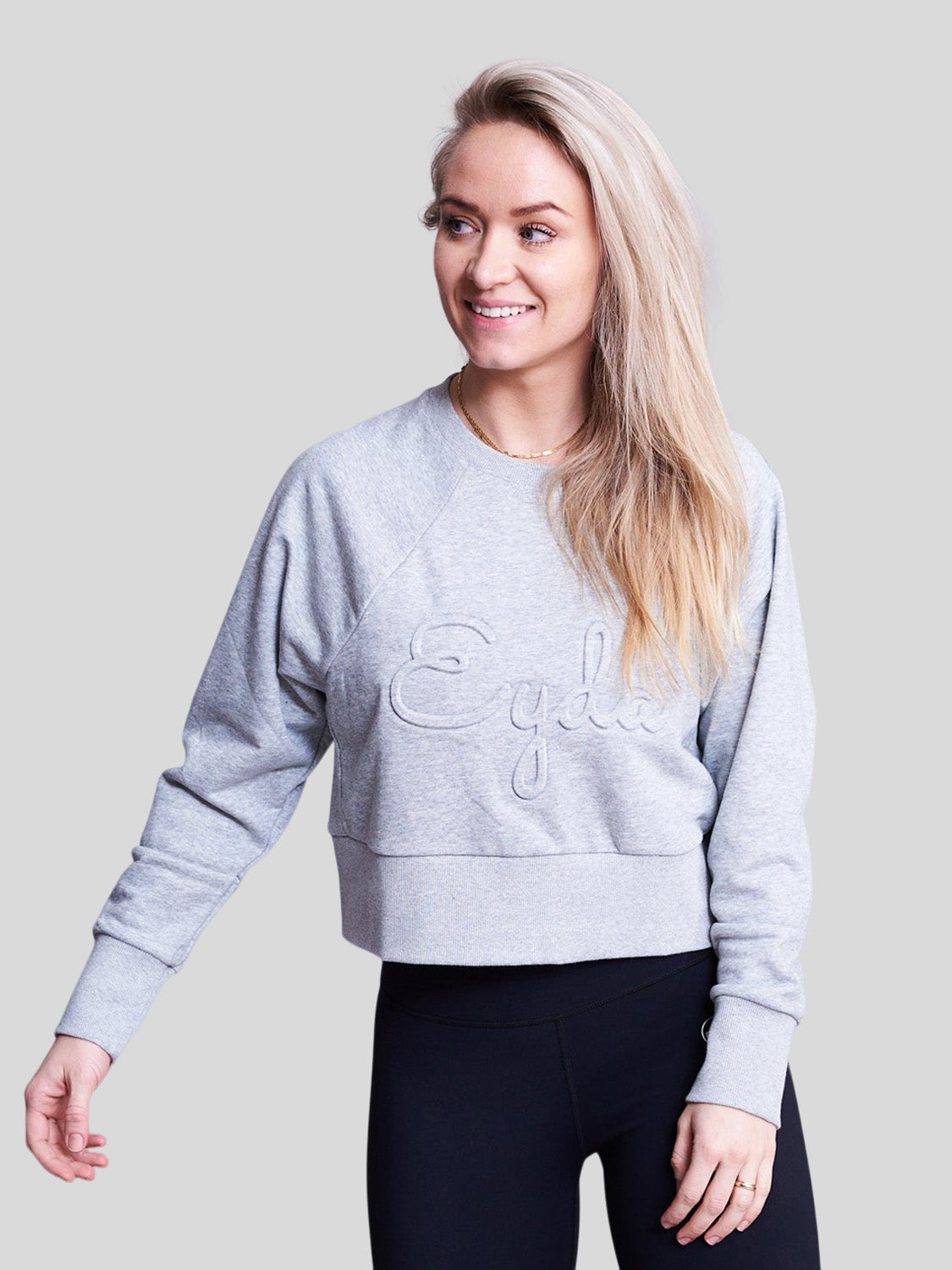 kvinde forfra i crop sweatshirt i grå med eyda logo foran