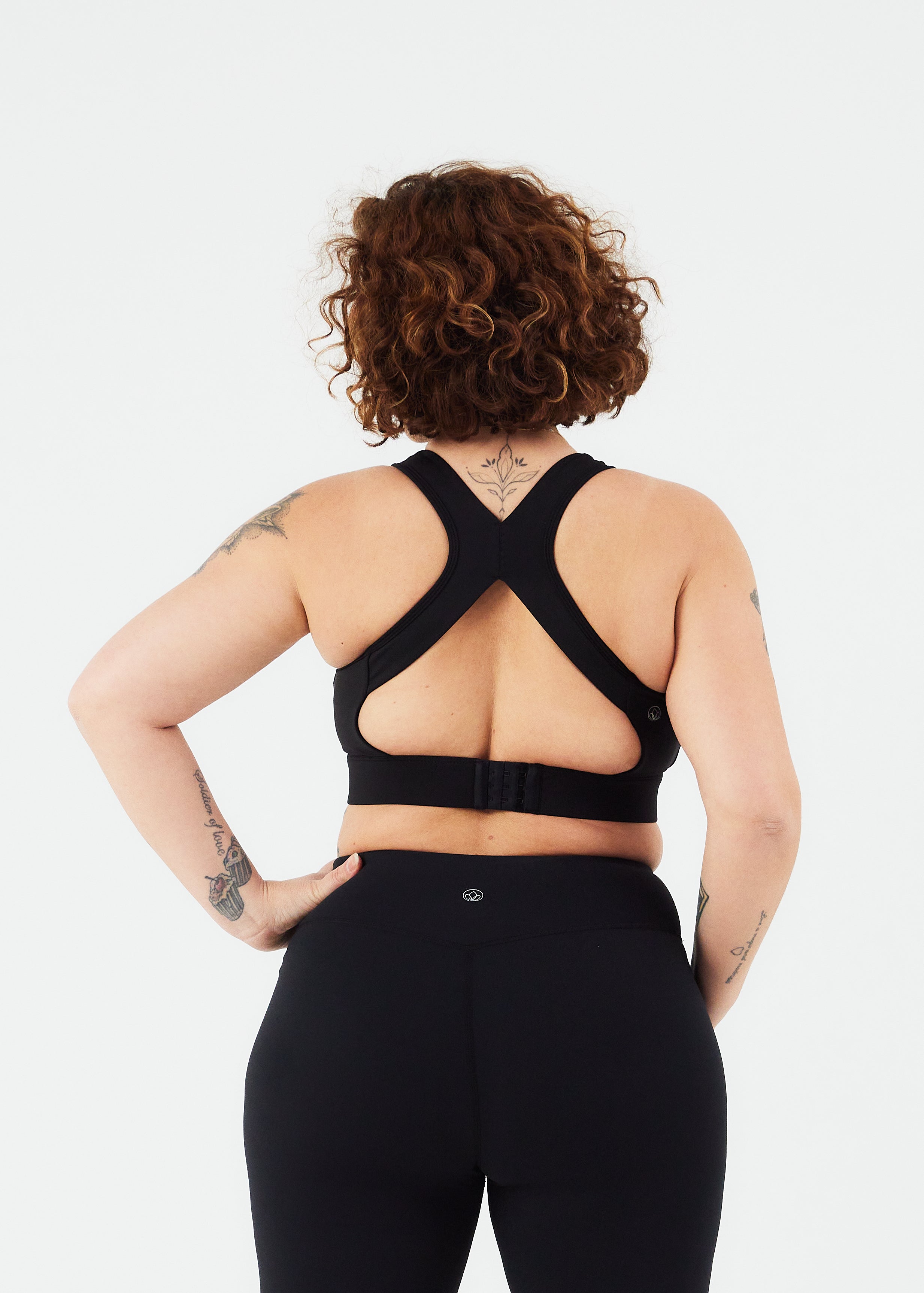kvinde med sort sports bh bagfra med åben ryg