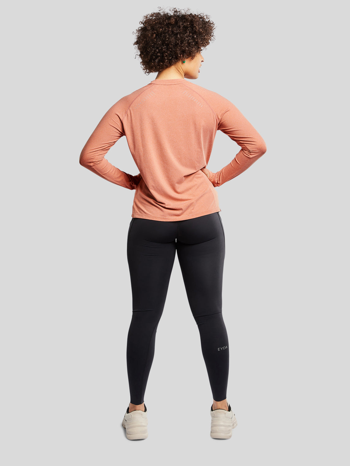 kvinde bagfra med træningstrøje i farven rust