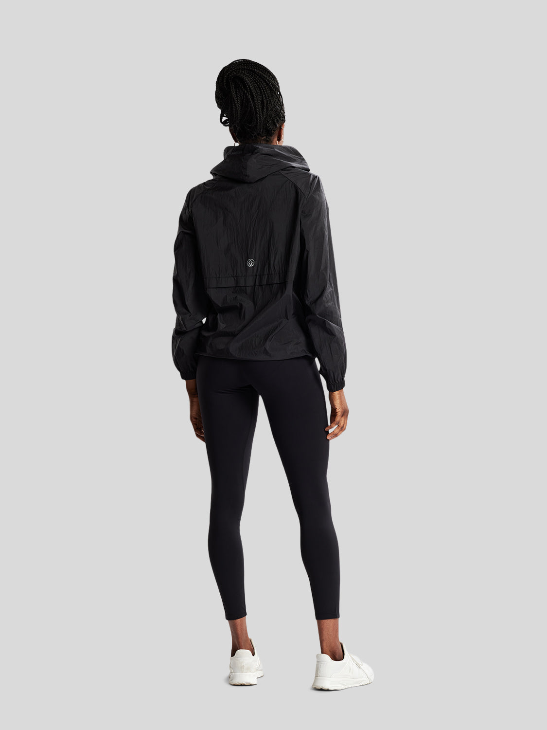 kvinde i fuld figur bagfra med sort træningsjakke