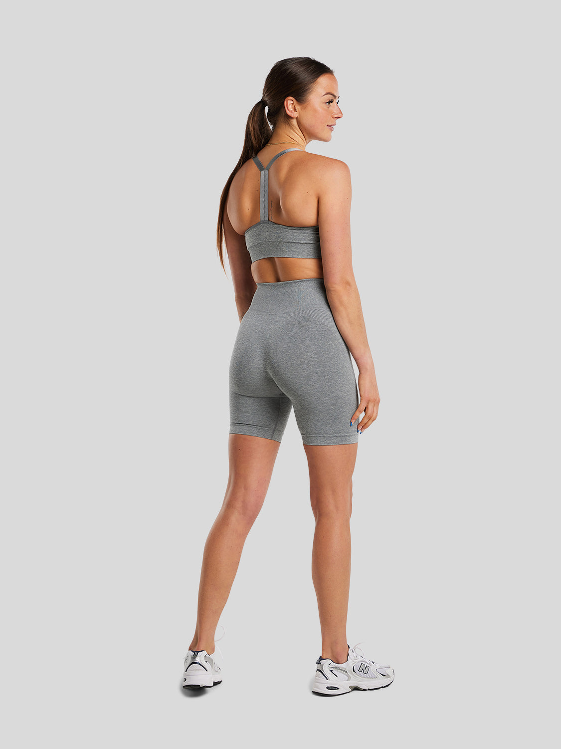 kvinde bagfra med seamless shorts og seamless sports bh i grey melange